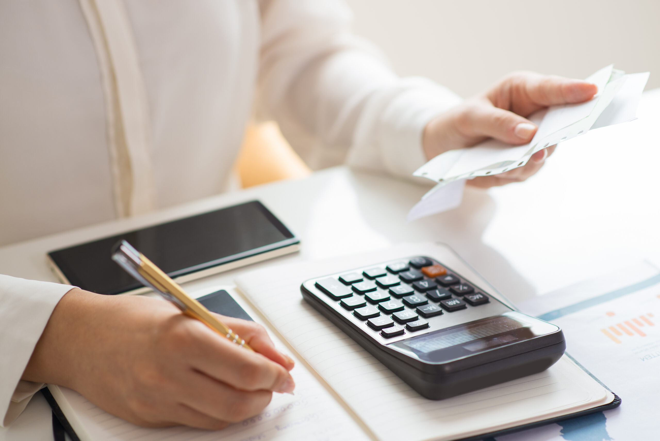 Business professional reviewing invoices and calculating transaction costs