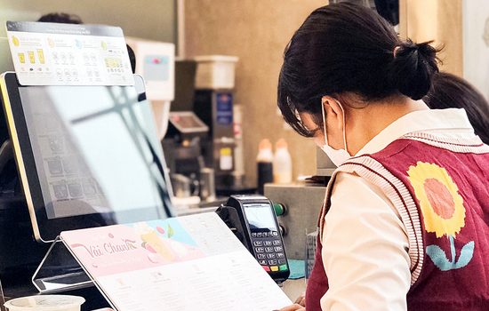 Cashier issuing a POS e-invoice to a customer at a retail store