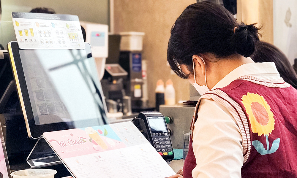 Cashier issuing a POS e-invoice to a customer at a retail store 