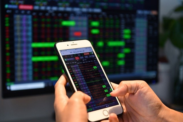 Investor monitoring stock market data on a smartphone, illustrating financial transactions in the banking, financial services, and insurance (BFSI) sector affected by Decree 254 and Circular 91.